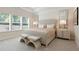 Comfortable bedroom with bench seating at the foot of the bed and natural light from the windows at 169 Hickory Bluffs Pkwy, Canton, GA 30114