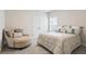 Cozy bedroom featuring a comfortable armchair, neutral decor, and a beautifully styled bed, creating a serene retreat at 169 Hickory Bluffs Pkwy, Canton, GA 30114