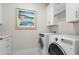 Well-equipped laundry room with front-load washer and dryer, custom cabinetry, and stylish decor, blending functionality with style at 169 Hickory Bluffs Pkwy, Canton, GA 30114