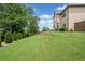 Spacious backyard with lush green grass and tiered landscaping, fenced for privacy at 2430 Tack Hill Ct, Dacula, GA 30019