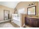 Bright bathroom featuring a soaking tub, dark wood vanity, and a large framed mirror at 2430 Tack Hill Ct, Dacula, GA 30019