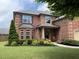 Charming two-story brick home featuring a manicured lawn and lush landscaping at 2430 Tack Hill Ct, Dacula, GA 30019