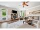 Relaxing living room featuring stone fireplace and plush sofa with an adjacent outdoor view at 2430 Tack Hill Ct, Dacula, GA 30019