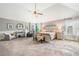 Spacious main bedroom with a tray ceiling, ceiling fan, and sitting area at 2430 Tack Hill Ct, Dacula, GA 30019