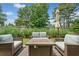 Outdoor patio features stylish seating area, gas fire pit, and lush green landscaping at 2430 Tack Hill Ct, Dacula, GA 30019