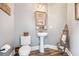 Charming powder room featuring a pedestal sink, decorative mirror, and wood-look flooring at 2430 Tack Hill Ct, Dacula, GA 30019