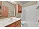 Cozy bathroom with wood cabinets, a large mirror, and a shower-tub combo with white tile at 4910 Aldbury Ln, Suwanee, GA 30024