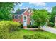 Beautiful two-story brick home with manicured lawn, lush trees, and charming curb appeal at 4910 Aldbury Ln, Suwanee, GA 30024