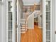 Elegant foyer with hardwood floors, staircase with white risers, and views to kitchen at 4910 Aldbury Ln, Suwanee, GA 30024