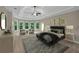 Spacious bedroom featuring tray ceilings, fan, area for sitting, neutral walls, and plush carpet at 4910 Aldbury Ln, Suwanee, GA 30024