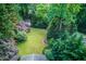Aerial view of large backyard including a storage shed, mature trees, and a lush green lawn at 6006 Lanier Heights Cir, Buford, GA 30518