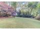 A spacious backyard featuring a large lawn and mature trees, offering a serene and private outdoor space at 6006 Lanier Heights Cir, Buford, GA 30518