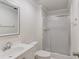 Bathroom featuring a shower with glass doors, white fixtures, a mirror, and white tile flooring at 6006 Lanier Heights Cir, Buford, GA 30518