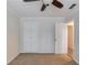 Neutral bedroom with ceiling fan, double closet, neutral carpet and trim, and an open door to the hallway at 6006 Lanier Heights Cir, Buford, GA 30518
