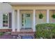 Inviting front porch with a teal door, brick accents, and well-maintained landscaping at 6006 Lanier Heights Cir, Buford, GA 30518