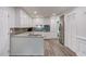 Open kitchen featuring white cabinets, stainless steel appliances and gray wood flooring at 6006 Lanier Heights Cir, Buford, GA 30518