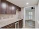Kitchen area featuring dark wood cabinets, stone countertops and stainless steel appliances at 6006 Lanier Heights Cir, Buford, GA 30518
