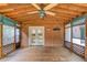 Covered porch with ceiling fan, wood floor, decorative lattice, and double doors at 6006 Lanier Heights Cir, Buford, GA 30518