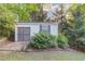 A well-maintained storage shed provides ample space for tools and equipment with privacy provided by lush greenery at 6006 Lanier Heights Cir, Buford, GA 30518