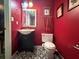 Compact bathroom with a pedestal sink, toilet, and striking red walls with geometric tile at 124 Tyler Dr, Mcdonough, GA 30252