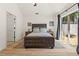 Bedroom with wood floors, ceiling fan, patio door, and a large bed with side tables at 4068 Cottage Oaks Dr, Acworth, GA 30101