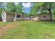 View of the back of the ranch-style home and spacious backyard with lush, green lawn at 4820 Yeager Rd, Douglasville, GA 30135