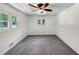 This bedroom is bright and features neutral walls and carpet and a ceiling fan at 4820 Yeager Rd, Douglasville, GA 30135