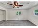 This bedroom is bright and features neutral walls and carpet and a ceiling fan at 4820 Yeager Rd, Douglasville, GA 30135
