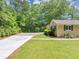 Ranch-style home showing a long driveway leading to a carport with a well-maintained lawn at 4820 Yeager Rd, Douglasville, GA 30135