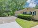 Side view of a ranch-style home with garage, carport, and well-maintained lawn with mature trees at 4820 Yeager Rd, Douglasville, GA 30135