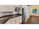Kitchen featuring dark countertops, stainless refrigerator, and white cabinets at 4820 Yeager Rd, Douglasville, GA 30135
