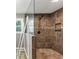 Walk-in shower with brown tiles, a rainfall shower head, and a partial glass enclosure at 4820 Yeager Rd, Douglasville, GA 30135