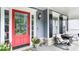 Inviting front porch features a vibrant red door, seating, and decorative plants at 118 Valleyside S Dr, Dallas, GA 30157