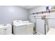 Clean laundry room featuring a modern washer and dryer, sink, storage shelves and hanging rack at 118 Valleyside S Dr, Dallas, GA 30157