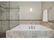 A luxurious, tiled bathtub with a glass-enclosed shower showcases elegance and relaxation at 2227 W Village Se Ln, Smyrna, GA 30080