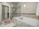 A tiled bathtub and glass-enclosed shower create a spa-like experience in this modern bathroom at 2227 W Village Se Ln, Smyrna, GA 30080