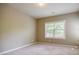 A well-lit bedroom with neutral walls, carpeted floors, and a window with natural light, creating a calm atmosphere at 2227 W Village Se Ln, Smyrna, GA 30080