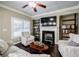 Cozy living room with fireplace, bookshelves, and comfortable seating at 2227 W Village Se Ln, Smyrna, GA 30080