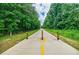 Tree-lined path featuring a paved surface and bollards, offering a scenic route for walking, running, or biking at 2227 W Village Se Ln, Smyrna, GA 30080