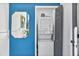 Laundry room featuring a stacked washer and dryer, framed by a vibrant blue wall and modern mirror at 3120 Godby Rd, Atlanta, GA 30349