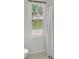 Brightly lit bathroom with a white shower curtain and a view of the house next door at 1411 Blackland Trl, Lawrenceville, GA 30043