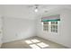 Bright bedroom with neutral carpet and trim featuring a ceiling fan and a green and black valance at 1411 Blackland Trl, Lawrenceville, GA 30043