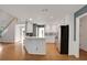 Open kitchen with white cabinets, stainless steel appliances, subway tile backsplash and views into the living area at 1411 Blackland Trl, Lawrenceville, GA 30043