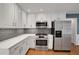 Bright, updated kitchen featuring stainless steel appliances, white cabinets, and a subway tile backsplash at 1411 Blackland Trl, Lawrenceville, GA 30043