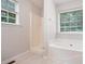 Bathroom showcasing a tub, separate shower, and a large window at 1595 Cedar Hl, Douglasville, GA 30134