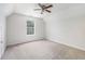 Bright bedroom features a ceiling fan, neutral carpet, vaulted ceiling, and large window at 1595 Cedar Hl, Douglasville, GA 30134