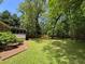 Large backyard features mature trees, green grass, and wood privacy fence at 3594 Broxton Ln, Snellville, GA 30039
