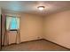 A cozy bedroom with neutral carpet, a window, and ceiling light fixture at 3594 Broxton Ln, Snellville, GA 30039