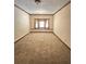 Living room featuring neutral walls, wood trim, carpet flooring, and a window at 3594 Broxton Ln, Snellville, GA 30039