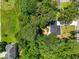 Aerial view of a black roof house surrounded by lush green trees and a well-maintained yard at 944 Pine Ridge Dr, Stone Mountain, GA 30087